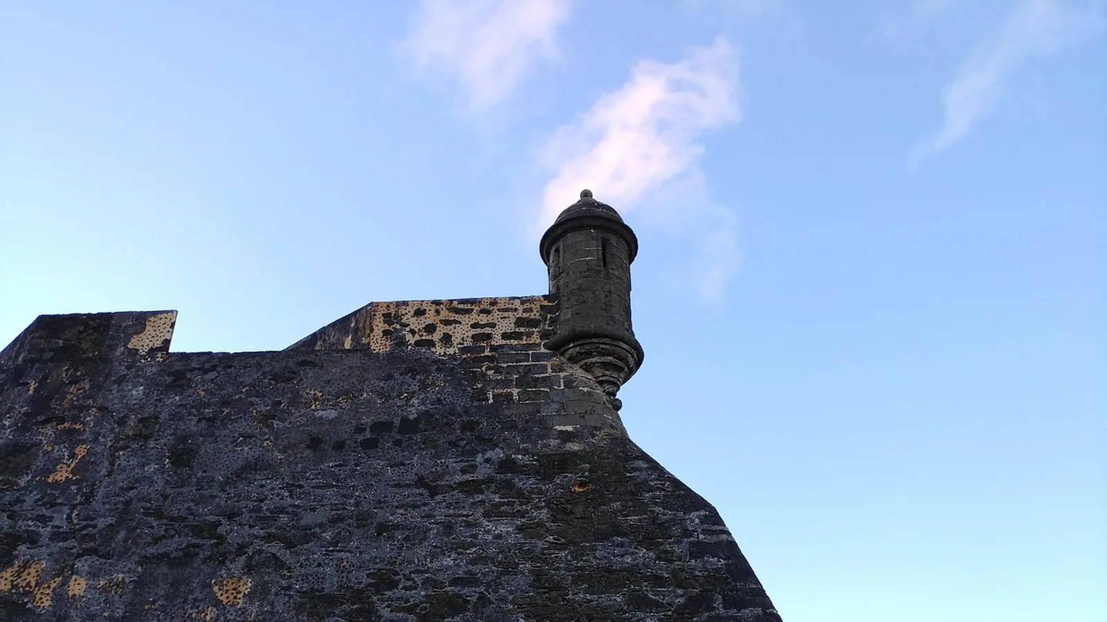 Stone fortress wall and sentry turret under a blue sky, illustrating a guide to presence test rules
