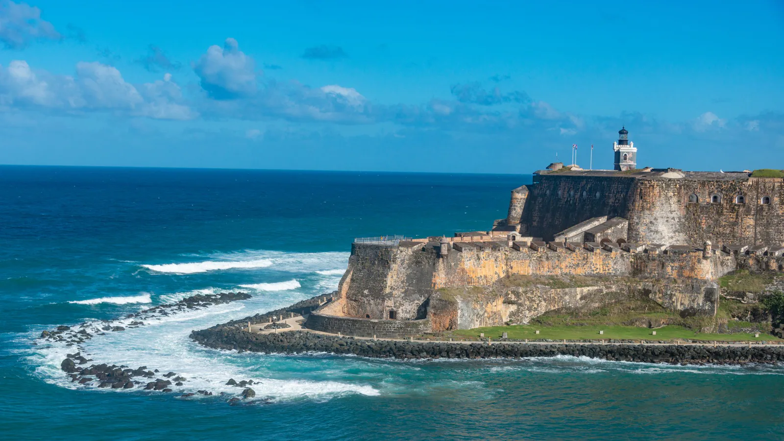 Stone walls and lighthouse of El Morro fort above blue surf, a Puerto Rico landmark for a tax home guide